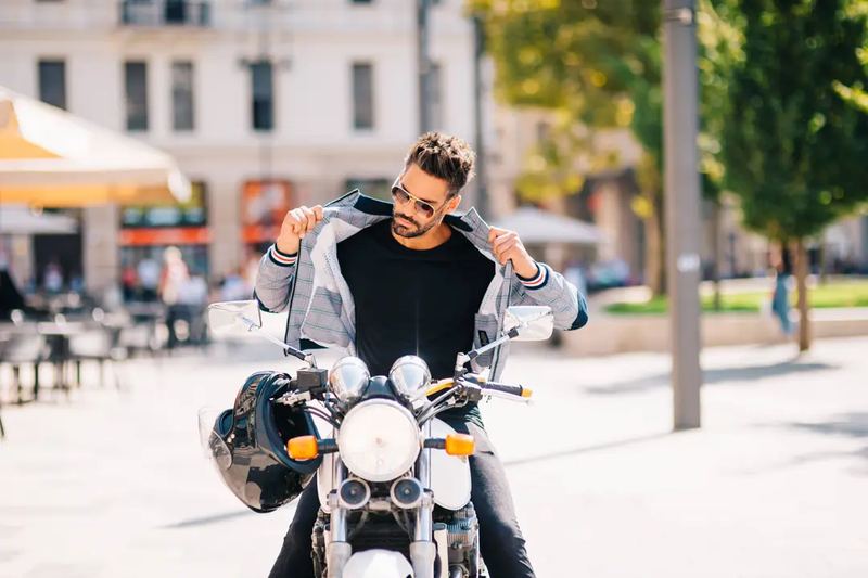 Man On a Motorbike Putting On a Jacket - Lifestyle Product Photography by Novkov Visuals