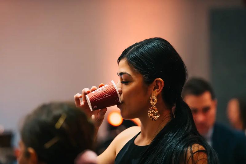 A lady drinking coffee from a Costa Cafe Cup