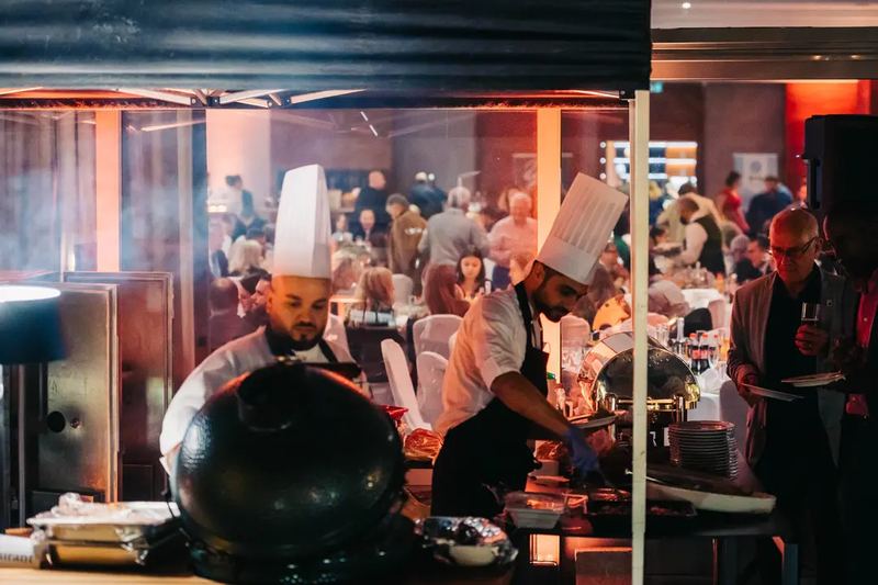 Chefs preparing food at a business gala event in Budapest