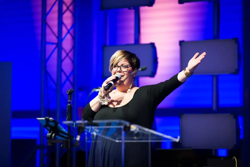 A lady giving a speech at a gala opening event in Budapest