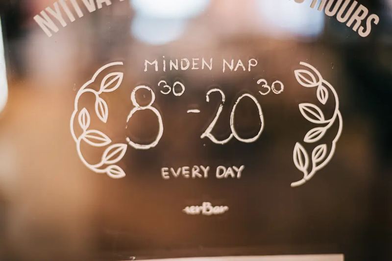 Open hours door drawing art at a local healthy food bar HerBar in downtown Budapest