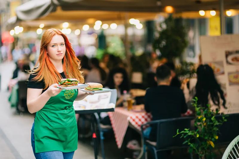 A waitress serving food on a terrace
