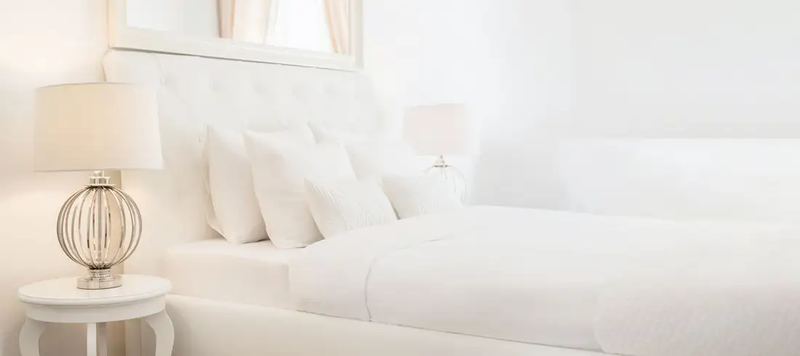 All white bedroom interior, shot on natural light by an expert interior photographer in Budapest